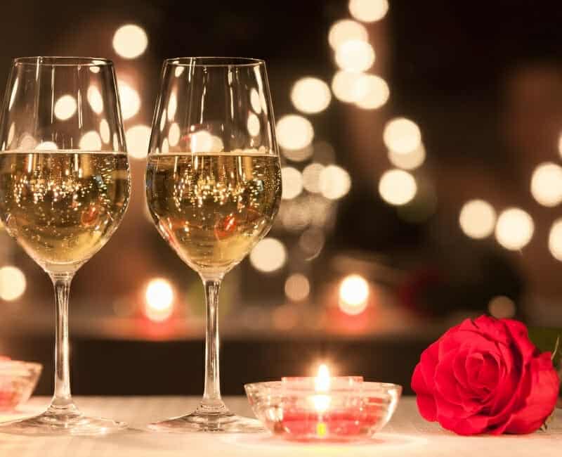 Best Experience Gifts Two glasses of wine and a rose on a table