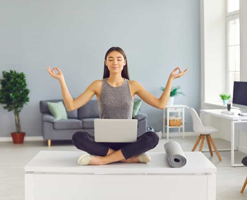 How to be intentional with your time: Woman meditating with laptop